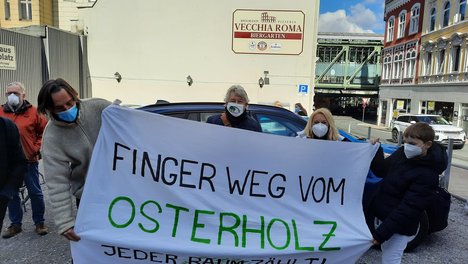 Susanne Herhaus und  Georg Dieker-Brennecke, DIE LINKE, Wuppertal, stehen hinter einem Transparent mit der Aufschrift "Finger weg vom Osterholz"