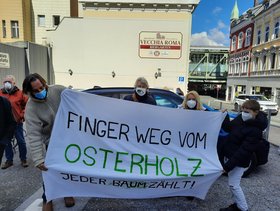 Susanne Herhaus und  Georg Dieker-Brennecke, DIE LINKE, Wuppertal, stehen hinter einem Transparent mit der Aufschrift "Finger weg vom Osterholz"